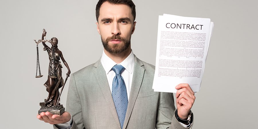 confident lawyer holding contract and themis statue while lookin