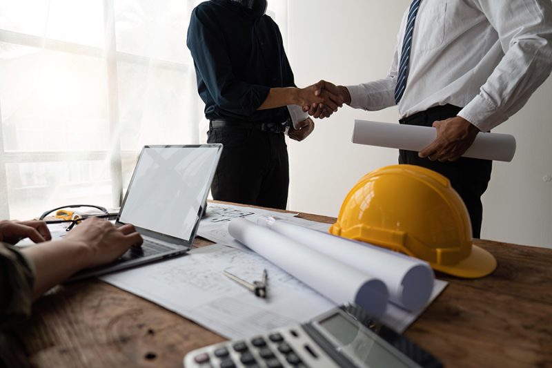 Professional Asian male engineer shaking hands with architect after meeting for agreement or contract