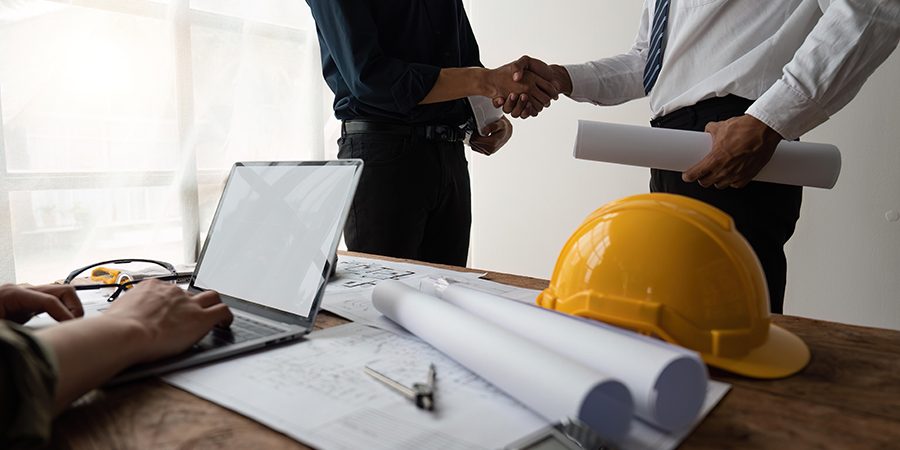 Professional Asian male engineer shaking hands with architect after meeting for agreement or contract