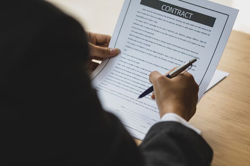 Female lawyer working in the office reading documents and signin