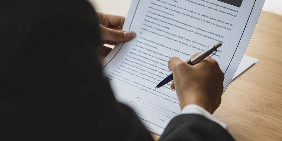 Female lawyer working in the office reading documents and signin