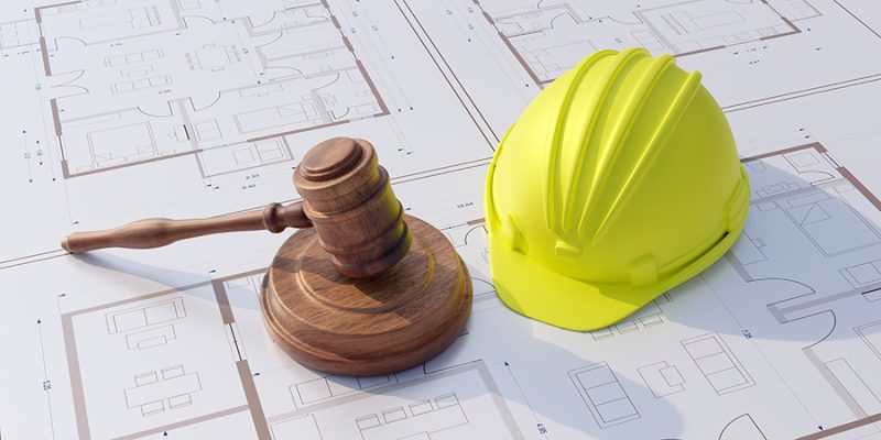 Labor, Construction law. Safety helmet and judge gavel on buildi
